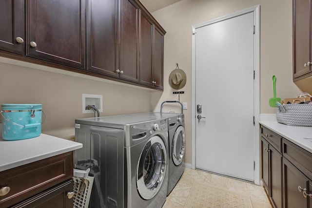 laundry room featuring separate washer and dryer and cabinets