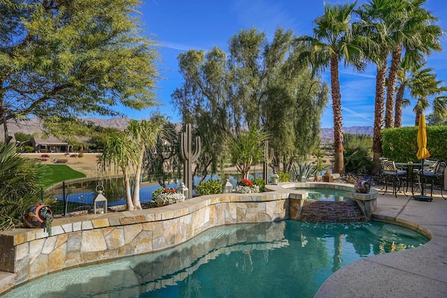 view of pool featuring an in ground hot tub, a mountain view, and a patio area