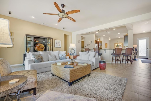 tiled living room with ceiling fan