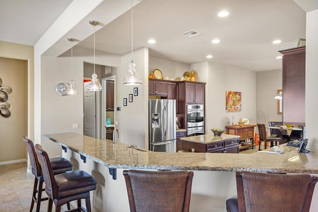 kitchen featuring sink, kitchen peninsula, pendant lighting, stainless steel appliances, and light stone countertops