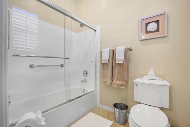 bathroom featuring enclosed tub / shower combo and toilet