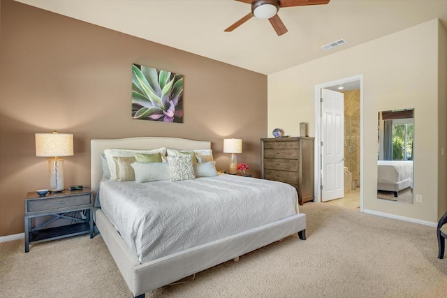 bedroom featuring ceiling fan, light colored carpet, and ensuite bath