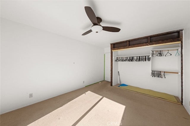 unfurnished bedroom featuring ceiling fan, a closet, and carpet flooring