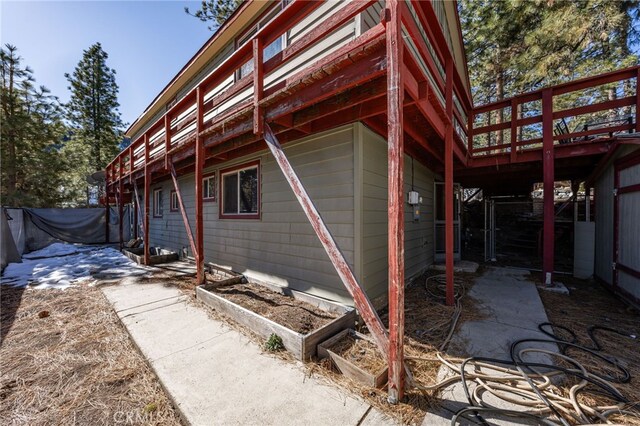 view of property exterior featuring a wooden deck and a patio