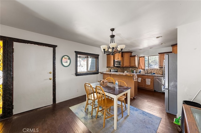 dining area with baseboards, dark wood-type flooring, and a notable chandelier