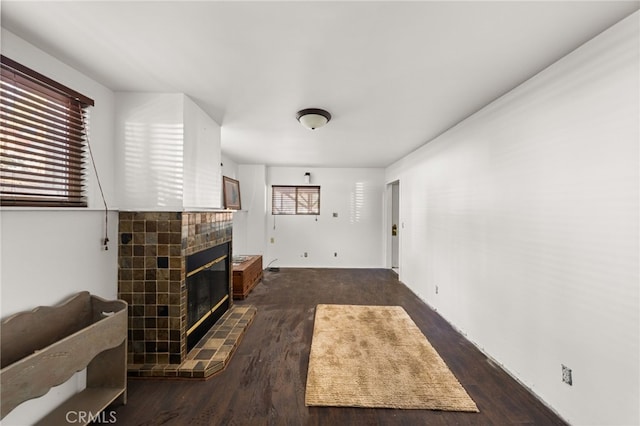 living area with a tile fireplace and wood finished floors