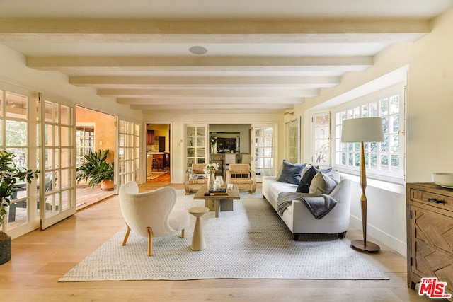 sunroom / solarium featuring beam ceiling and french doors