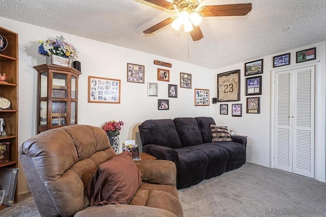 living room with ceiling fan, carpet, and a textured ceiling