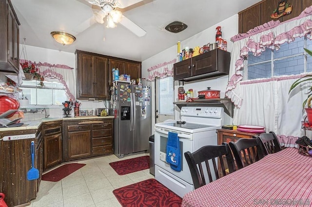 kitchen with stainless steel refrigerator with ice dispenser, sink, dark brown cabinets, ceiling fan, and white range with electric cooktop