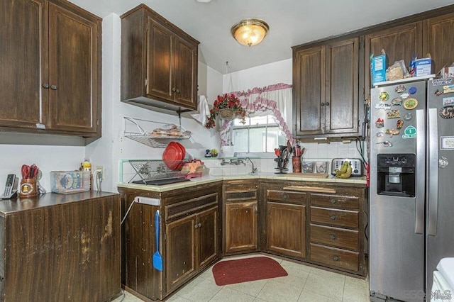 kitchen with backsplash, stainless steel fridge, and dark brown cabinetry