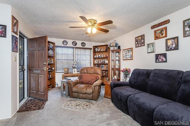 living room featuring ceiling fan, light colored carpet, and a textured ceiling