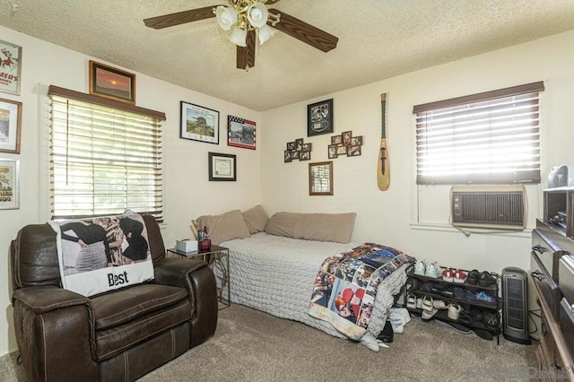 carpeted bedroom featuring ceiling fan and a textured ceiling