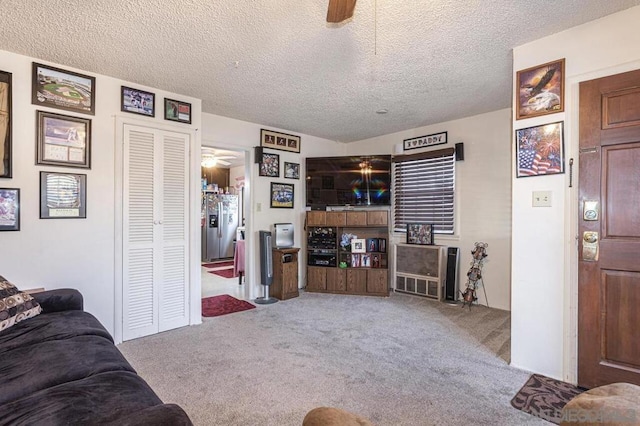 carpeted living room featuring a textured ceiling and ceiling fan