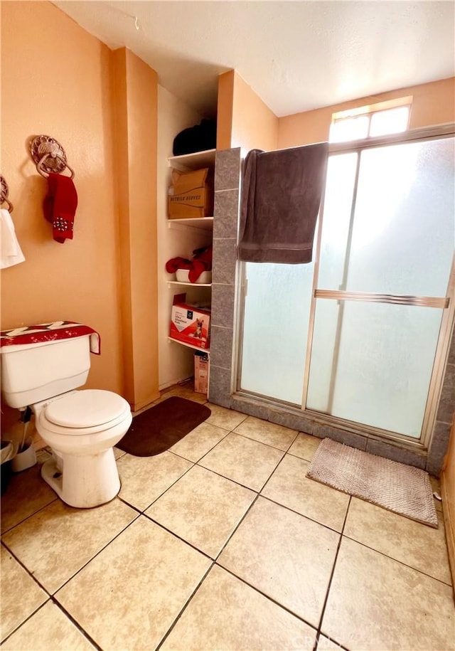 bathroom with an enclosed shower, tile patterned floors, and toilet