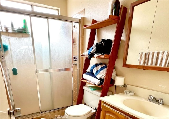 bathroom with vanity, an enclosed shower, and toilet