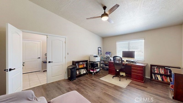 office with vaulted ceiling, a textured ceiling, ceiling fan, and light hardwood / wood-style floors