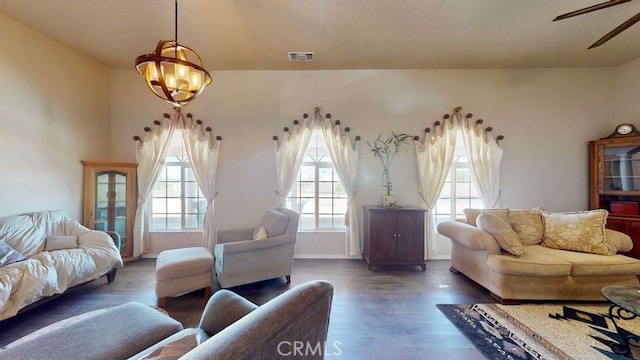 living room with dark wood-type flooring and ceiling fan with notable chandelier