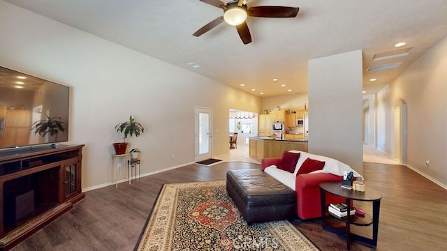 living room featuring dark wood-type flooring and ceiling fan