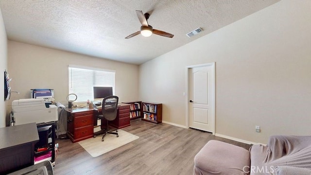 office area featuring a textured ceiling, vaulted ceiling, light hardwood / wood-style floors, and ceiling fan