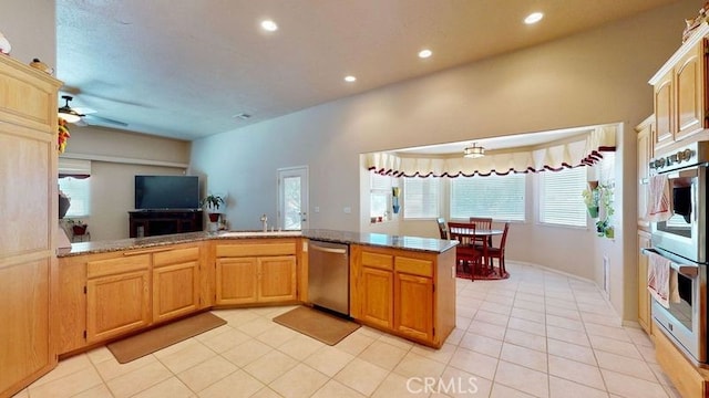 kitchen featuring sink, light tile patterned floors, ceiling fan, kitchen peninsula, and stainless steel appliances