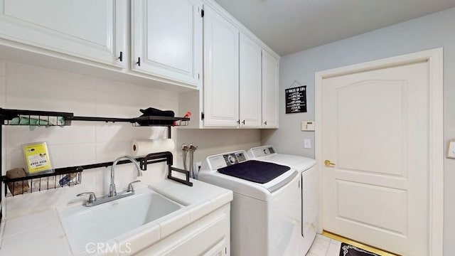 laundry area featuring sink, cabinets, and washing machine and clothes dryer