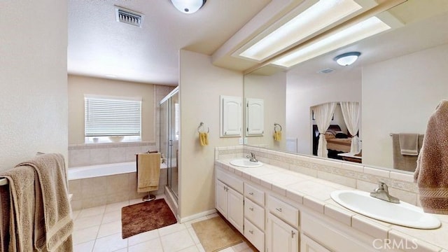 bathroom with vanity, tile patterned floors, and plus walk in shower