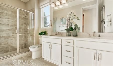 bathroom featuring vanity, toilet, and an enclosed shower