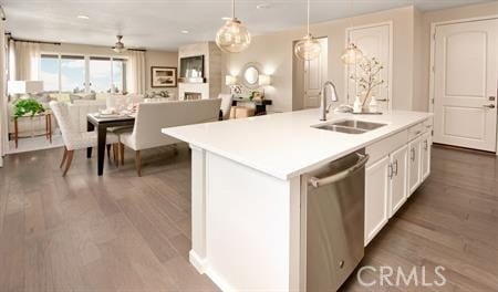 kitchen with sink, hanging light fixtures, dishwasher, a kitchen island with sink, and white cabinets