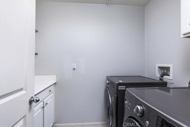 washroom featuring washing machine and dryer and cabinets