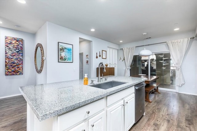 kitchen featuring sink, white cabinetry, a kitchen island with sink, decorative light fixtures, and stainless steel dishwasher