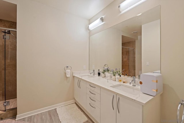 bathroom featuring wood-type flooring, vanity, and a shower with shower door