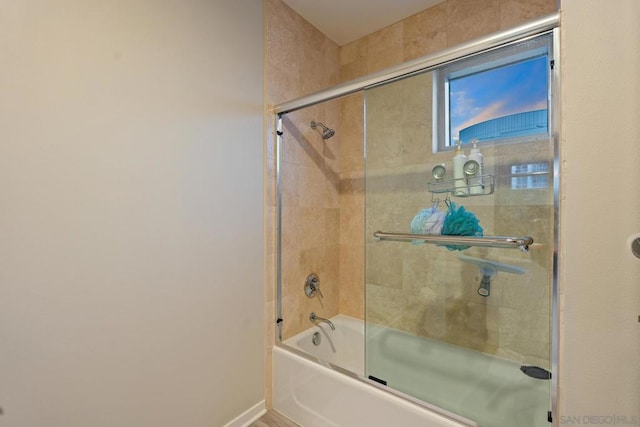 bathroom with bath / shower combo with glass door