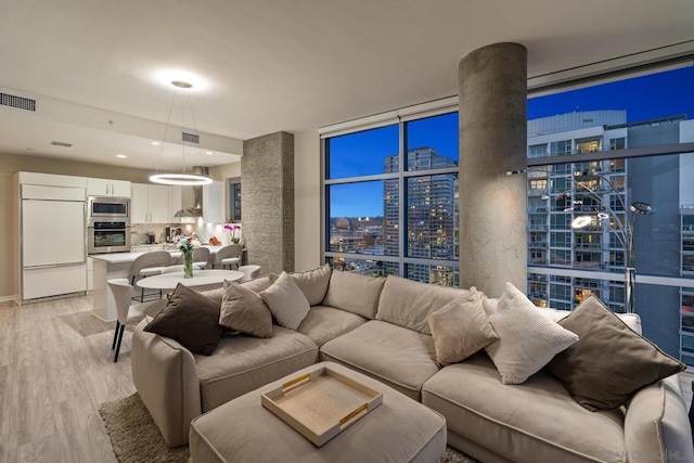 living room featuring floor to ceiling windows and light hardwood / wood-style floors