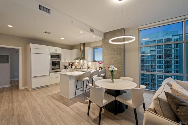 dining space featuring sink and light wood-type flooring