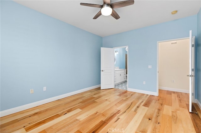 unfurnished bedroom with ceiling fan, ensuite bath, and light wood-type flooring