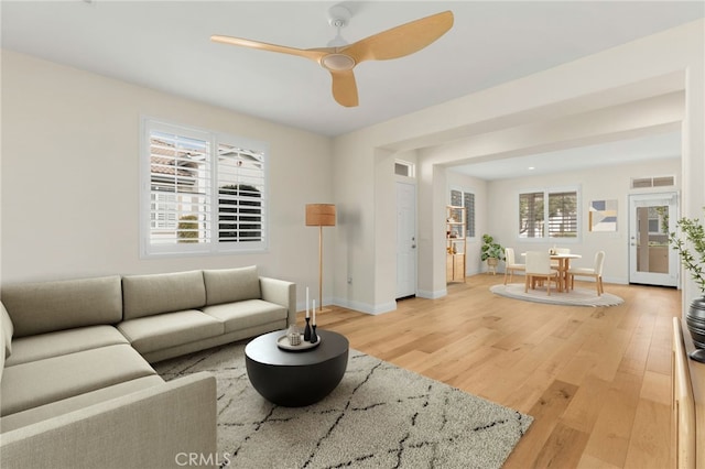 living room featuring hardwood / wood-style floors and ceiling fan