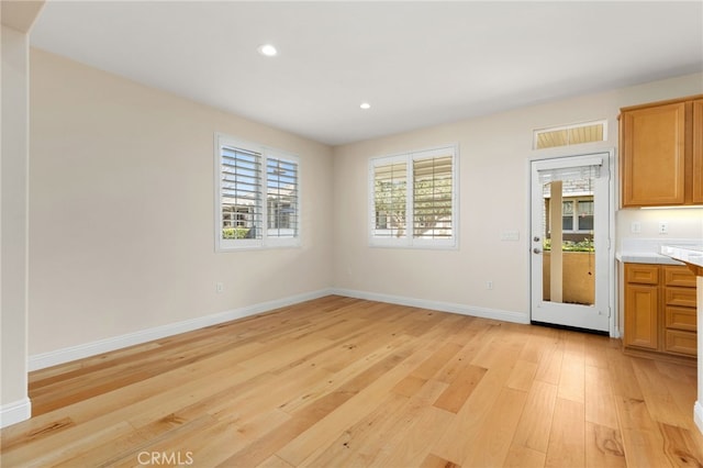 unfurnished dining area featuring light wood-type flooring