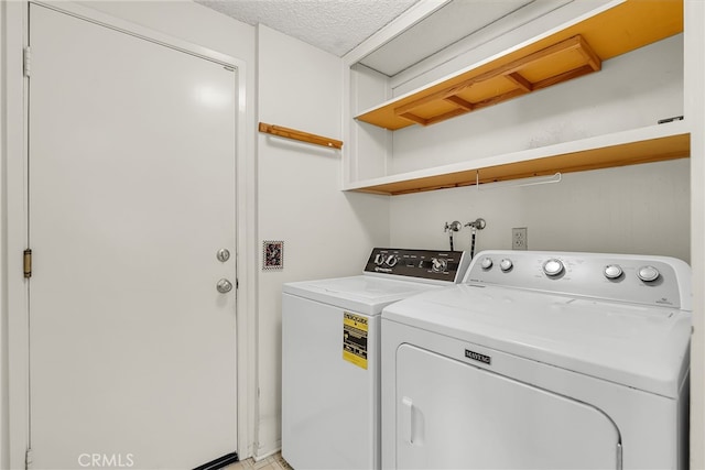 washroom with a textured ceiling and independent washer and dryer