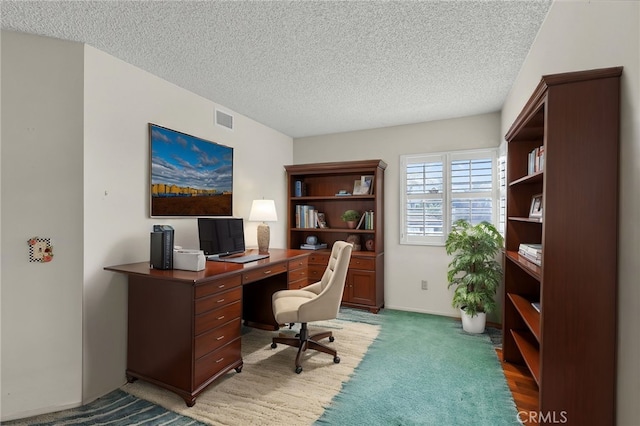 home office with a textured ceiling and dark colored carpet