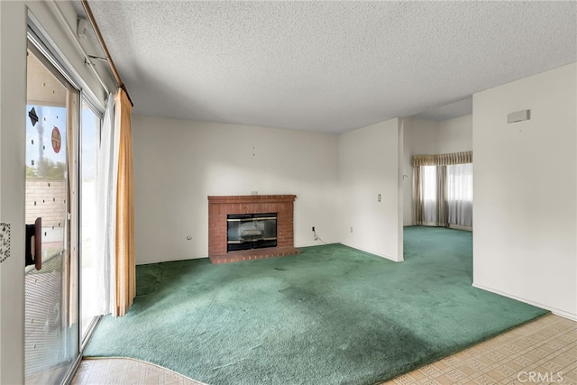 unfurnished living room featuring carpet floors, a textured ceiling, and a fireplace