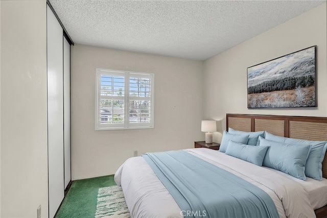 bedroom featuring dark carpet and a textured ceiling