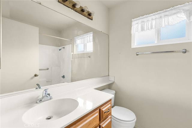 bathroom with vanity, a shower, and toilet