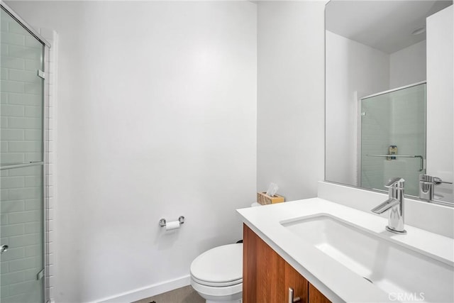 bathroom featuring vanity, an enclosed shower, and toilet