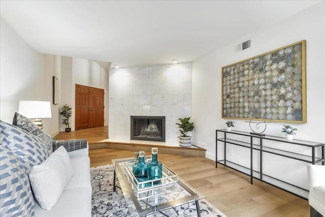 living room featuring a tile fireplace and hardwood / wood-style floors