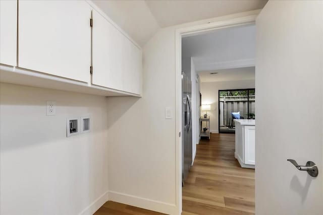 laundry area with cabinets, washer hookup, and light hardwood / wood-style flooring