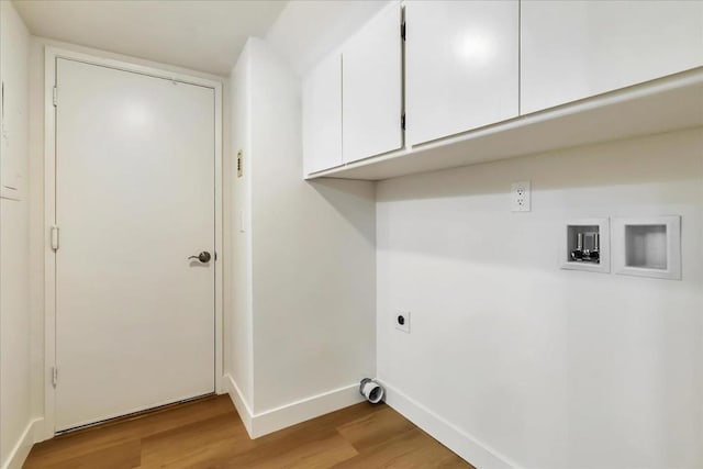 laundry room featuring cabinets, electric dryer hookup, and light hardwood / wood-style floors