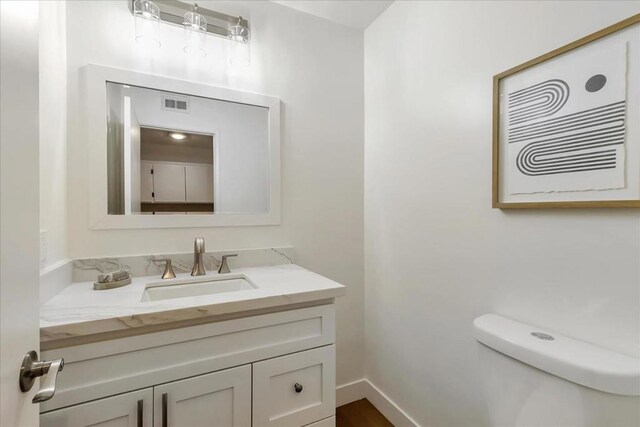 bathroom featuring vanity and toilet