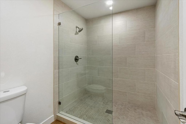 bathroom with toilet and tiled shower