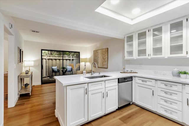 kitchen featuring white cabinetry, dishwasher, sink, kitchen peninsula, and light hardwood / wood-style flooring