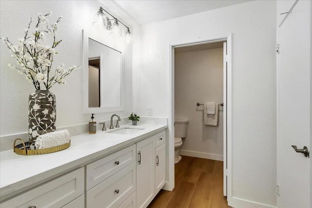 bathroom with vanity, hardwood / wood-style flooring, and toilet